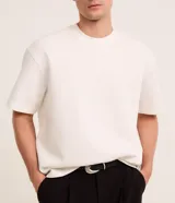 Remera masculina de corte boxy, color marrón oscuro, con cuello redondo y mangas cortas. Confeccionada en malla pesada con textura gomosa.