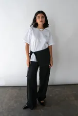 Pantalón de vestir negro, de corte recto y tiro alto, con bolsillos laterales y pretina trasera elastizada.