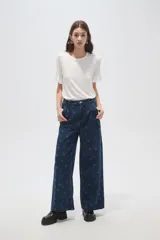 Pantalón de jean azul oscuro de corte ancho, con tiro alto, pinzas frontales y estampado de lunares.