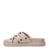 Sandalias planas Miss Carol modelo Nami, color beige, con múltiples tiras cruzadas decoradas con tachas metálicas plateadas y suela tipo plataforma baja.