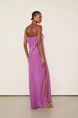 Vestido largo lila de viscosa con tirantes finos, escote recto con lazo ajustable, silueta fluida, tajo lateral en la falda y detalles de encaje en el canesú del busto.