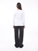 Remera de punto color gris claro, con escote en V y mangas largas.