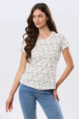 Remera de algodón de manga corta y cuello redondo, con delicado estampado floreado sobre base beige.