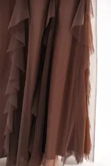 Pollera larga color marrón chocolate, confeccionada en tejido translúcido con múltiples capas y volados en cascada.