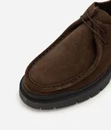 Zapato masculino de cuero con textura gamuza, diseño moc toe y suela track robusta. Cuenta con cordones cortos y tirador trasero reforzado.
