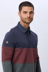 Remera polo de algodón de manga larga con diseño en bloques de color azul marino, bordó y verde oscuro. Tiene cuello y solapa de botones en azul marino.
