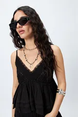 Top blanco con breteles finos y detalle de encaje en el escote.