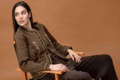 Chaqueta color chocolate con cierre frontal mediante lazos, manga larga y bordados decorativos en los paneles frontales.