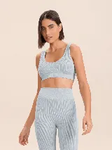 Top deportivo de tejido acanalado con escote en V y diseño sin costuras. Cuenta con relleno extraíble y tecnología de alta transpirabilidad para mayor comodidad.