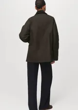 Parka verde militar con cuello camisero de pana negra, cierre frontal de cremallera y botones a presión, bolsillos frontales con solapa y forro interior.
