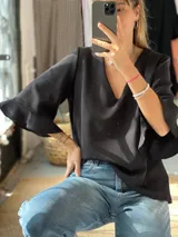 Blusa de crepé color negro, con escote en V y mangas tres cuartos con terminación de volados.