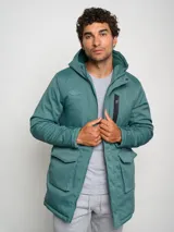 Parka larga gris con capucha, cierre frontal con cremallera y botones a presión, múltiples bolsillos y logo de Umbro en el pecho.