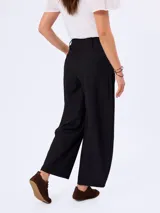 Pantalón barrel negro de corte ancho y relajado, confeccionado en poliéster con bolsillos laterales y cintura de tiro medio.
