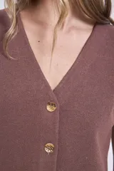 Chaleco de punto color crema con escote en V y cierre frontal con botones a tono.