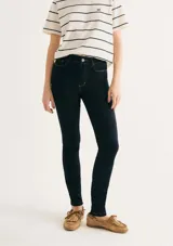 Pantalón de jean corte skinny, de tiro medio y color azul oscuro con costuras en contraste.