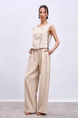 Pantalón de lino color beige, de corte palazzo con pinzas en la cintura.