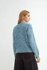Cardigan de tejido de punto jaspeado en tonos rosados y violetas, con cuello redondo y cierre frontal de botones marrones.