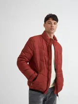 Campera capitoneada color ladrillo, con cuello alto, cierre frontal y bolsillos laterales con cierre.