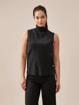 Polera sin mangas de tejido de punto color gris, con cuello alto vuelto y costuras decorativas frontales.