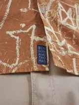 Camisa de manga larga color ladrillo con estampado abstracto en blanco.