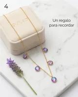 Collar de cadena fina dorada con cinco dijes colgantes redondos de cristal facetado en tono violeta tornasolado.