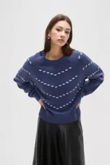 Sweater de punto color azul con diseño de fantasía en forma de líneas curvas punteadas en color celeste. Presenta cuello redondo a la base, mangas largas con puños acanalados y corte holgado.
