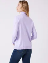 Polera de tejido fino, color rosado, con cuello alto, manga larga y detalle de tajo en los puños.