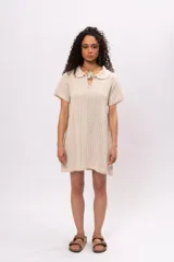 Vestido corto color crema, tejido a crochet con cuello polo y mangas cortas.