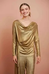 Top de manga larga color dorado, con escote drapeado tipo cowl y detalle de lazo ajustable en el lateral.