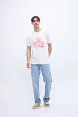 Remera blanca de manga corta con cuello redondo y un estampado central en color rojo que simula un arrecife de coral dentro de un arco.