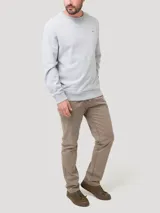 Buzo de algodón orgánico color gris melange, de diseño clásico con cuello redondo, manga larga y terminaciones en rib. Cuenta con un pequeño parche bordado con forma de pato en el pecho.