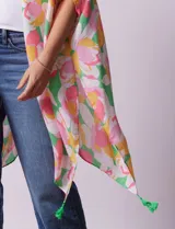 Kimono tejido con estampado floral multicolor y terminación de ruedo con borlas verdes.