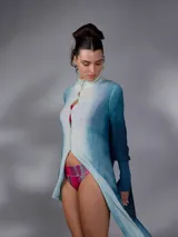 Saco largo de lana merino tejido con diseño jacquard de ramas, de líneas rectas y aberturas laterales, con efecto degradado en tonos azules y blancos, mangas largas con puños entallados y cierre frontal con pequeños botones.