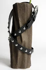 Cinturón negro de cuero sintético con tachas plateadas y hebilla metálica plateada.