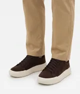 Championes casuales de color marrón oscuro, confeccionados en material sintético con acabado liso, cordones al tono y suela chunky de goma en tono marfil.