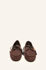 Mocasín estilo náutico de gamuza marrón, con cordones de cuero, borla decorativa y cuentas de colores en el empeine.