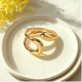 Anillo dorado de acero quirúrgico con diseño abierto orgánico.