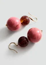 Aros colgantes compuestos por dos cuentas esféricas de acrílico, una superior más pequeña en tono marrón oscuro translúcido y otra inferior más grande jaspeada en tonos rosados, con gancho metálico dorado.