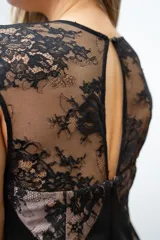 Vestido midi negro con encaje floral sobre base color piel, corte ajustado y escote cuadrado.