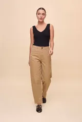 Pantalón de tiro alto y calce barrel, con piernas amplias que se afinan hacia los tobillos. Diseño con bolsillos delanteros y traseros, presillas y cierre frontal con botón y cremallera.
