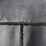 Campera de cuero sintético negro con interior y detalles de piel sintética al tono. Presenta cierre frontal metálico, bolsillos frontales con solapa y diseño de corte recto.