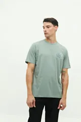 Remera de manga corta color verde agua, con calce regular y estampa gráfica pequeña en el pecho.