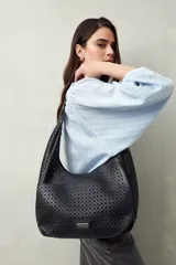 Cartera de hombro color beige con diseño calado y estructura semirrígida.