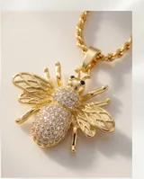 Cadena de acero con baño de oro y dije de bronce en forma de abeja, decorado con circonias brillantes.
