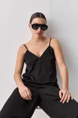 Top negro de breteles finos con escote en V y diseño minimalista, confeccionado en tela fluida y suave.