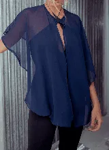 Capa corta color fucsia de gasa, estilo torerita, con mangas amplias y abertura frontal.