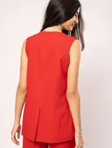 Chaleco color crema de lino con corte sastrero, largo a la cadera, forro interno, botones delanteros, silueta levemente entallada y tajo cruzado en la espalda.