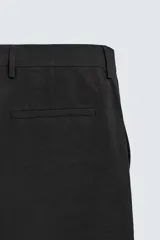Pantalón de traje con corte relaxed fit, confeccionado en una mezcla de viscosa y lino. Presenta bolsillos laterales delanteros, bolsillos traseros de vivo y cierre frontal con cremallera y gancho oculto.