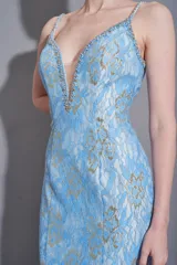 Vestido largo de fiesta celeste con encaje floral dorado, escote en V profundo y breteles finos con detalles de pedrería.