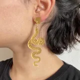 Par de aros colgantes con forma de serpiente plateada con detalles en negro.